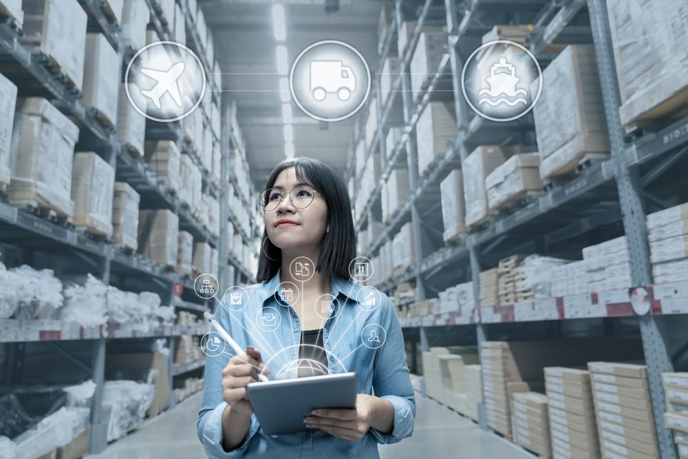 Woman in shipping warehouse using shipping software to create a seamless shipping process.